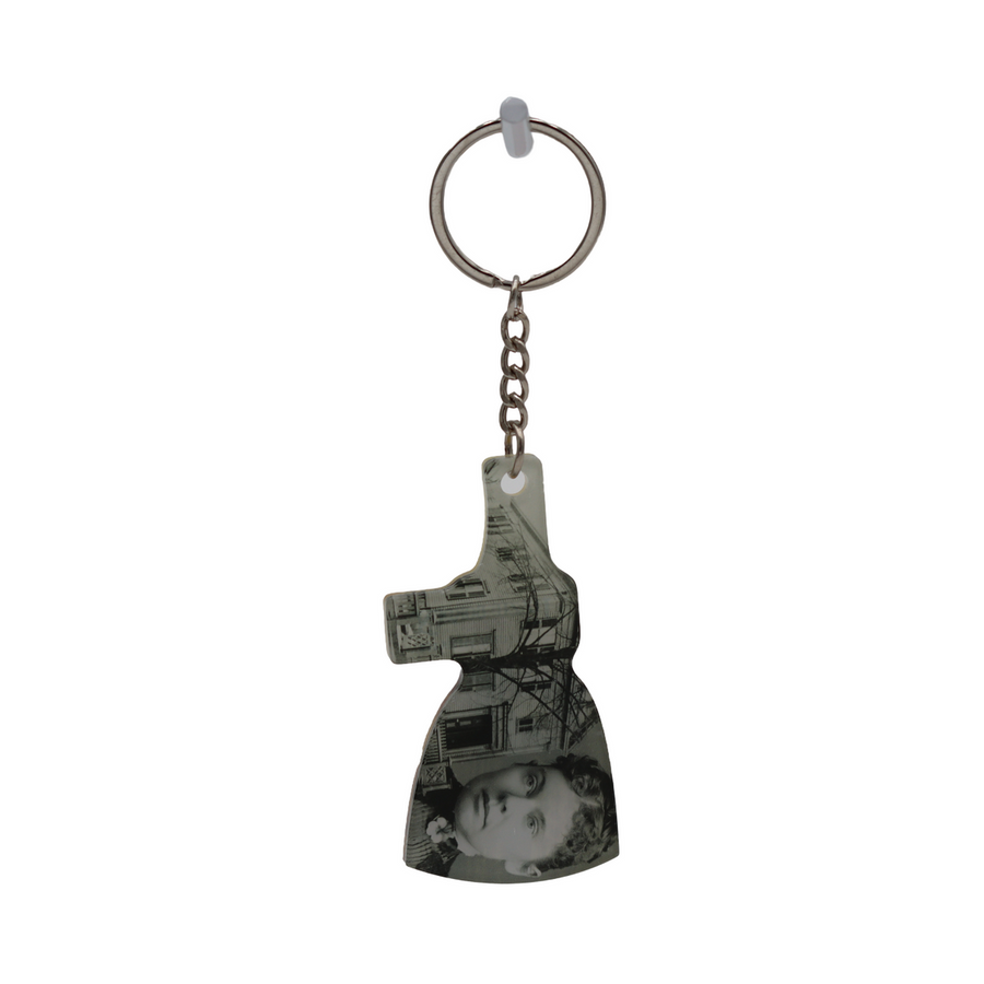 A keychain featuring a silhouette of the Lizzie Borden House with an axe head design.