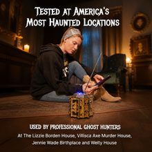 Person using a device on a wooden floor with text about haunted locations and ghost hunters.