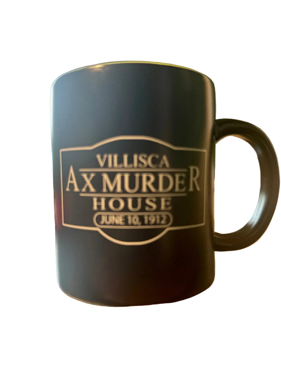 Black mug with 'Villisca Ax Murder House' text on a wooden surface